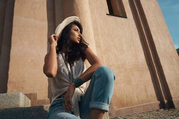 Thoughtful indian lady in casual summer outfit against ancient building. — Stock Photo, Image