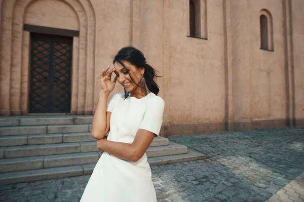Skrattande indisk dam i vit klänning mot gammal byggnad — Stockfoto
