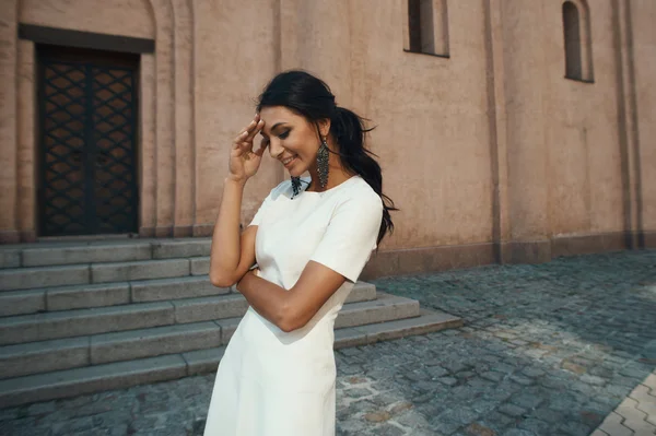 Antik Bina karşı beyaz elbiseli Hintli kadın gülüyor