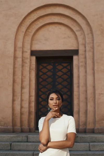 Flirten Indiase dame in witte jurk tegen oude gebouw — Stockfoto