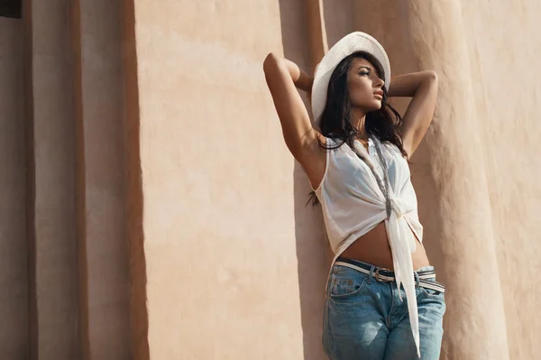 Thoughtful indian lady in casual summer outfit against ancient building. — Stock Photo, Image