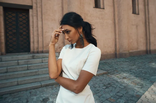 Donna indiana in abito bianco contro edificio antico con sguardo premuroso — Foto Stock