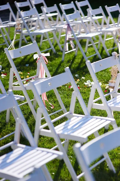rows of white chairs arranged for a wedding ceremony