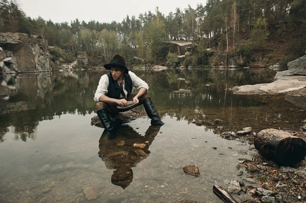 Săpătorul de aur neras spală aurul în lac cu o bancă stâncoasă — Fotografie, imagine de stoc