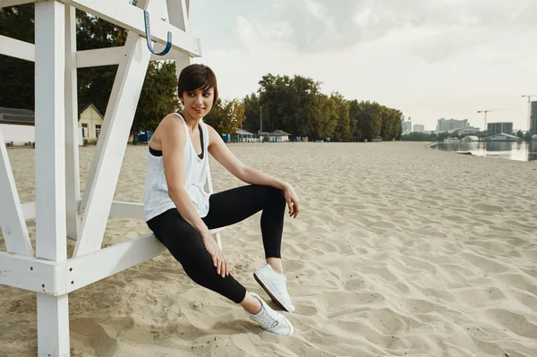 Brunette with short haircut sitting on volleyball seat — Stock Photo, Image