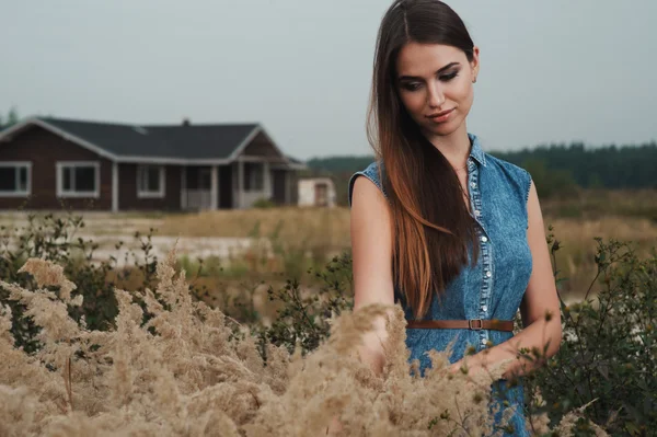 Cute countryside lady standing in tall grass against ranch house — Stock Photo, Image