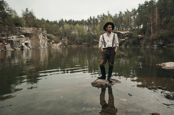tıraşsız avcısı kayalık banka ile gölde kayada duran