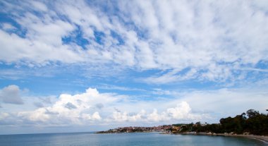 Denizin üzerinde kabarık bulutlar ile mavi gökyüzü 