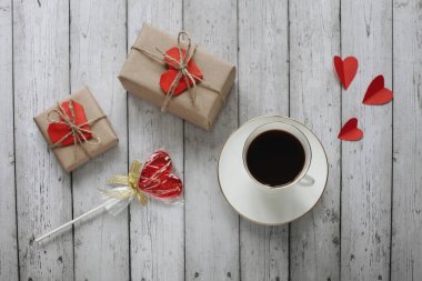 Sevgililer Günü 'nde düz romantik fotoğrafçılık, tahta bir arka planda bir fincan kahveyle yatıyordu.. 