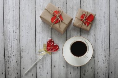 Sevgililer Günü 'nde düz romantik fotoğrafçılık, tahta bir arka planda bir fincan kahveyle yatıyordu.. 