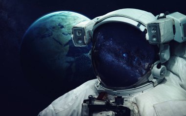 Uzay yürüyüşünde astronot. Kozmik sanat, bilim kurgu duvar kağıdı. Uzay giysisi vizöründe yansıma. Evrende milyarlarca galaksi var. Bu görüntünün elementleri NASA tarafından desteklenmektedir