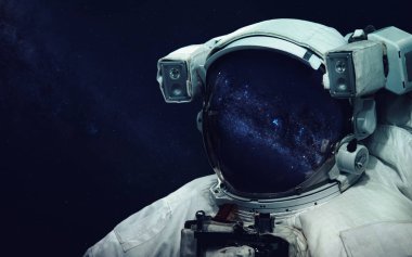 Uzay yürüyüşünde astronot. Kozmik sanat, bilim kurgu duvar kağıdı. Uzay giysisi vizöründe yansıma. Evrende milyarlarca galaksi var. Bu görüntünün elementleri NASA tarafından desteklenmektedir
