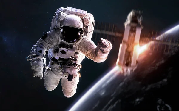 Astronauta na caminhada espacial, satélite orbitando o planeta Terra. Elementos desta imagem fornecidos pela NASA — Fotografia de Stock