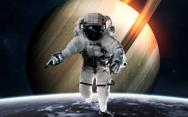 Satürn ve astronot gezegenin önünde. Güneş sistemi. Bu görüntünün elementleri NASA tarafından desteklenmektedir