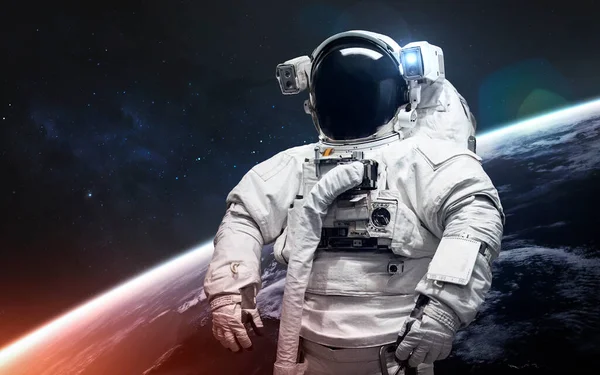 Űrhajós az űrsétányon. Csodálatos gyönyörű Föld bolygó hideg és meleg fényben. A kép elemeit a NASA bocsátotta rendelkezésre — Stock Fotó