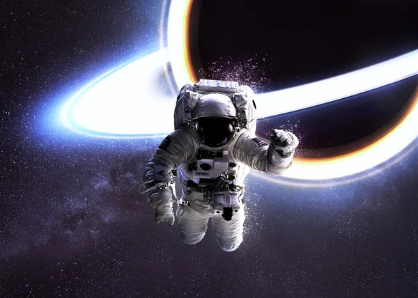 Űrhajós a világűrben ellen a fekete lyuk. Ez a kép a Nasa berendezett elemei. — Stock Fotó