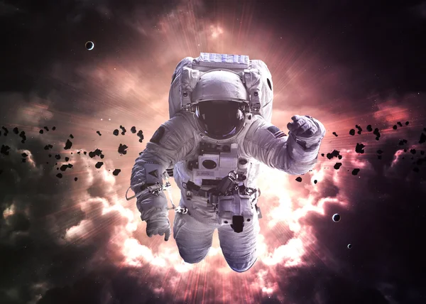 An astronaut floats above billions of stars. Stars provide the background. Elements of this Image Furnished by NASA. — Stock fotografie