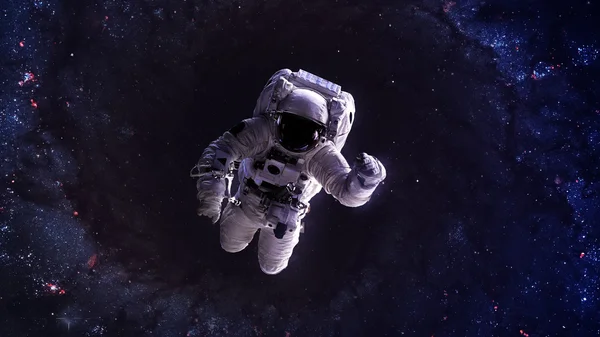 An astronaut floats above billions of stars. Stars provide the background. Elements of this Image Furnished by NASA. — Stock Photo, Image