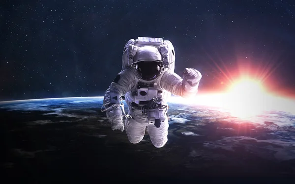 Astronaut i yttre rymden mot bakgrund av planeten jorden. Delar av denna bild tillhandahålls av NASA. — Stockfoto