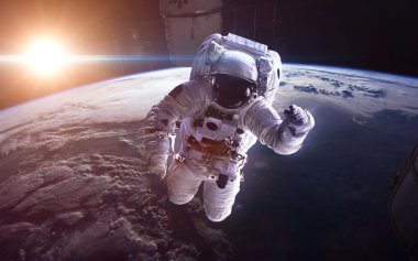 Uzaydaki astronot, Dünya gezegeninin arka planına karşı. Bu görüntünün elementleri NASA tarafından desteklenmektedir