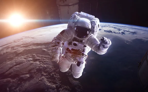 Uzaydaki astronot, Dünya gezegeninin arka planına karşı. Bu görüntünün elementleri NASA tarafından desteklenmektedir