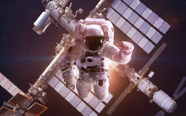 International Space Station with astronaut over the planet Earth. Elements of this image furnished by NASA