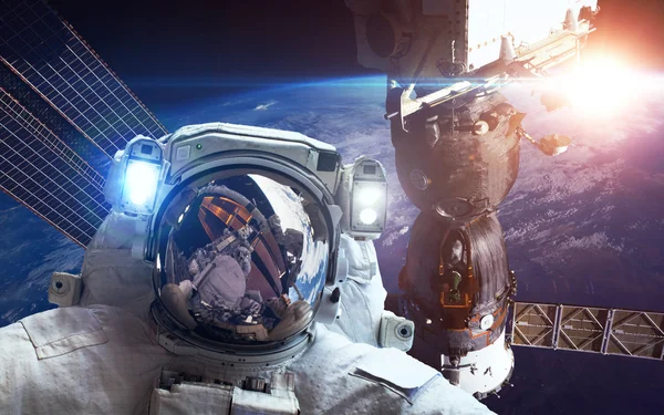 Международная космическая станция с астронавтом над планетой Земля. Элементы этого изображения предоставлены НАСА — стоковое фото