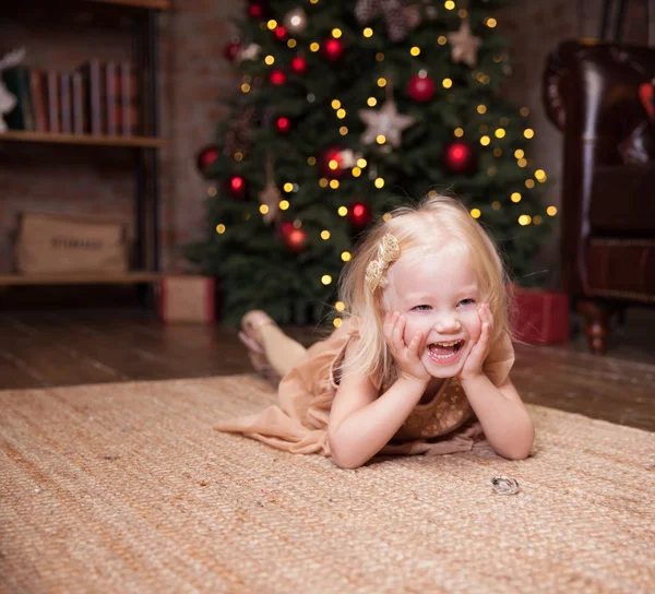 Kleines Mädchen unterm Weihnachtsbaum — Stockfoto
