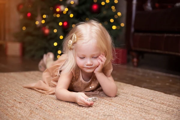 Meisje onder de kerstboom Rechtenvrije Stockfoto's