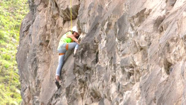 Joven mujer tratando por primera vez a la roca escalar — Vídeos de Stock