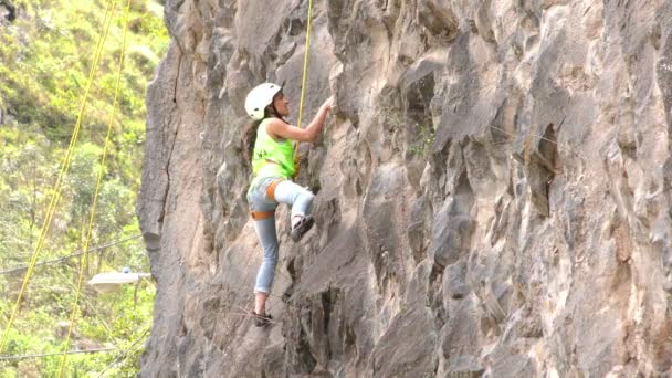 Joven mujer tratando por primera vez a la roca escalar — Vídeo de stock