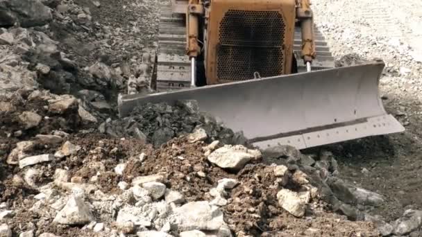 Vista frontal de la topadora moviendo rocas hacia la cámara — Vídeos de Stock
