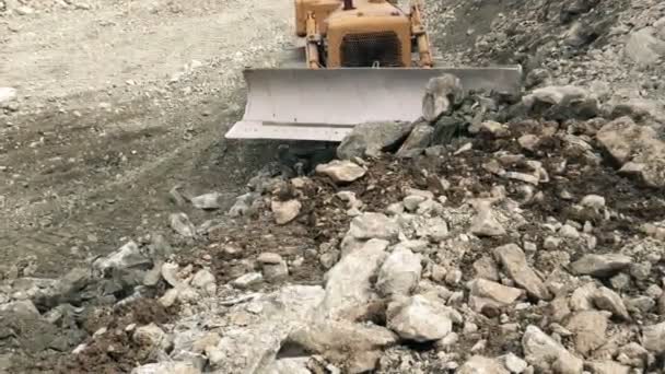 Frontansicht eines Bulldozers, der Felsen in Richtung Kamera bewegt — Stockvideo