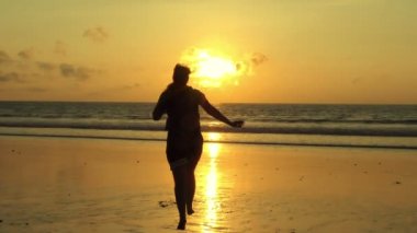 Kumsalda koşan kadın.