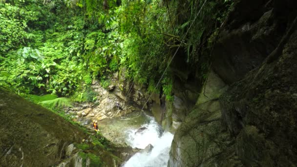 Les femmes touristiques sont envoyées par tyrolienne sur la cascade pendant le canyoning 