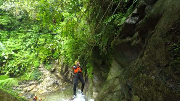 Turist kvinnor skickas av änterhaken över vattenfallet medan Canyoning — Stockvideo