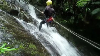 Ekvador yağmur ormanlarında bir şelale Rappelling Asya kız