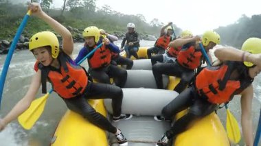 İki Asyalı kız beyaz su Rafting önde gelen tekne