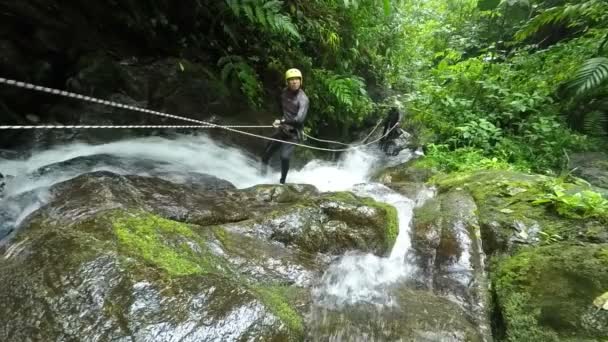 Hombre Funny Face While Rappelling A Waterfall — Vídeo de stock