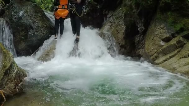 Las mujeres que caen en una pequeña cascada — Vídeos de Stock