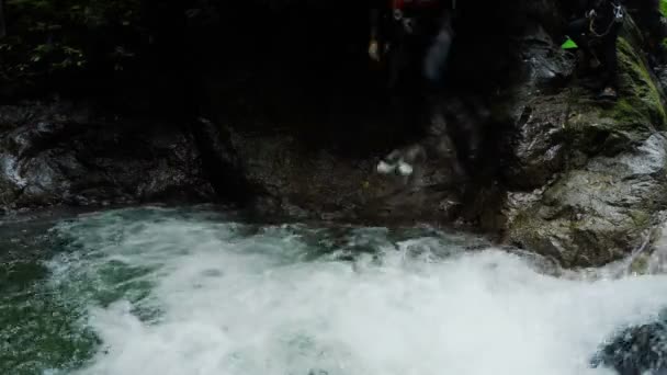 Aktive Männer springen in Wasserfall — Stockvideo