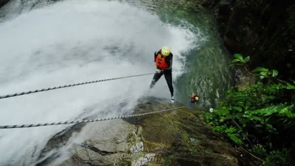 Deux touristes Rappelling creux grande chute d'eau — Video