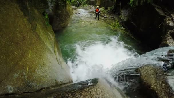 Aktive Frau springt in Wasserfall — Stockvideo