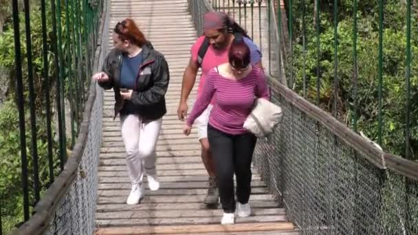 Turista atravessando uma ponte suspensa — Vídeo de Stock