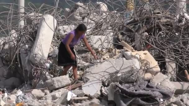 Egy nő, aki drága Cooper drótot keres egy földrengésben lerombolt épületben. — Stock videók