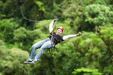 Adult Man On Zip Line Against Blurred Forest clipart