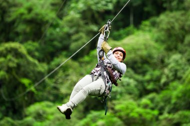 Adult Woman On Zip Line Against Blurred Forest clipart