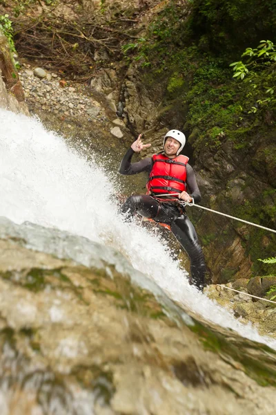 Valiente adulto hombre rappel un cascada — Foto de Stock