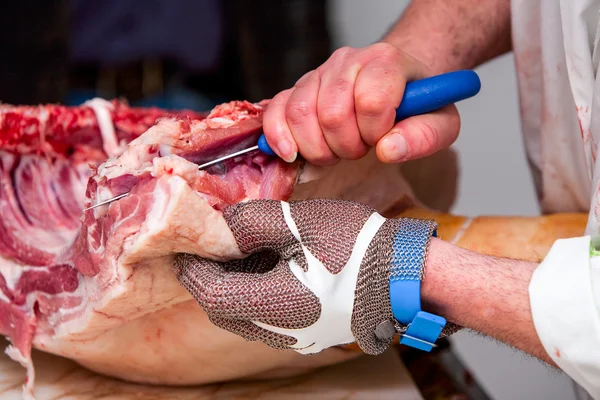 Macellaio che taglia carne di maiale fresca — Foto Stock