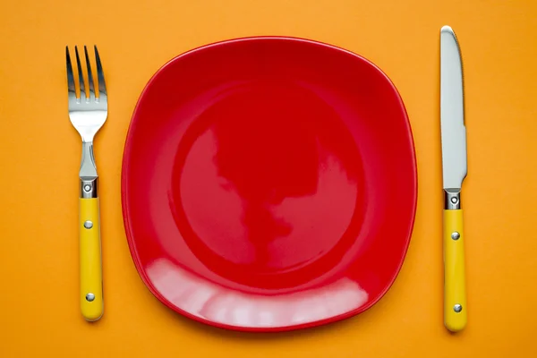 Red plate on orange — Stock Photo, Image